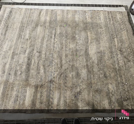 שטיח מונח על רשת מתכת לניקוי